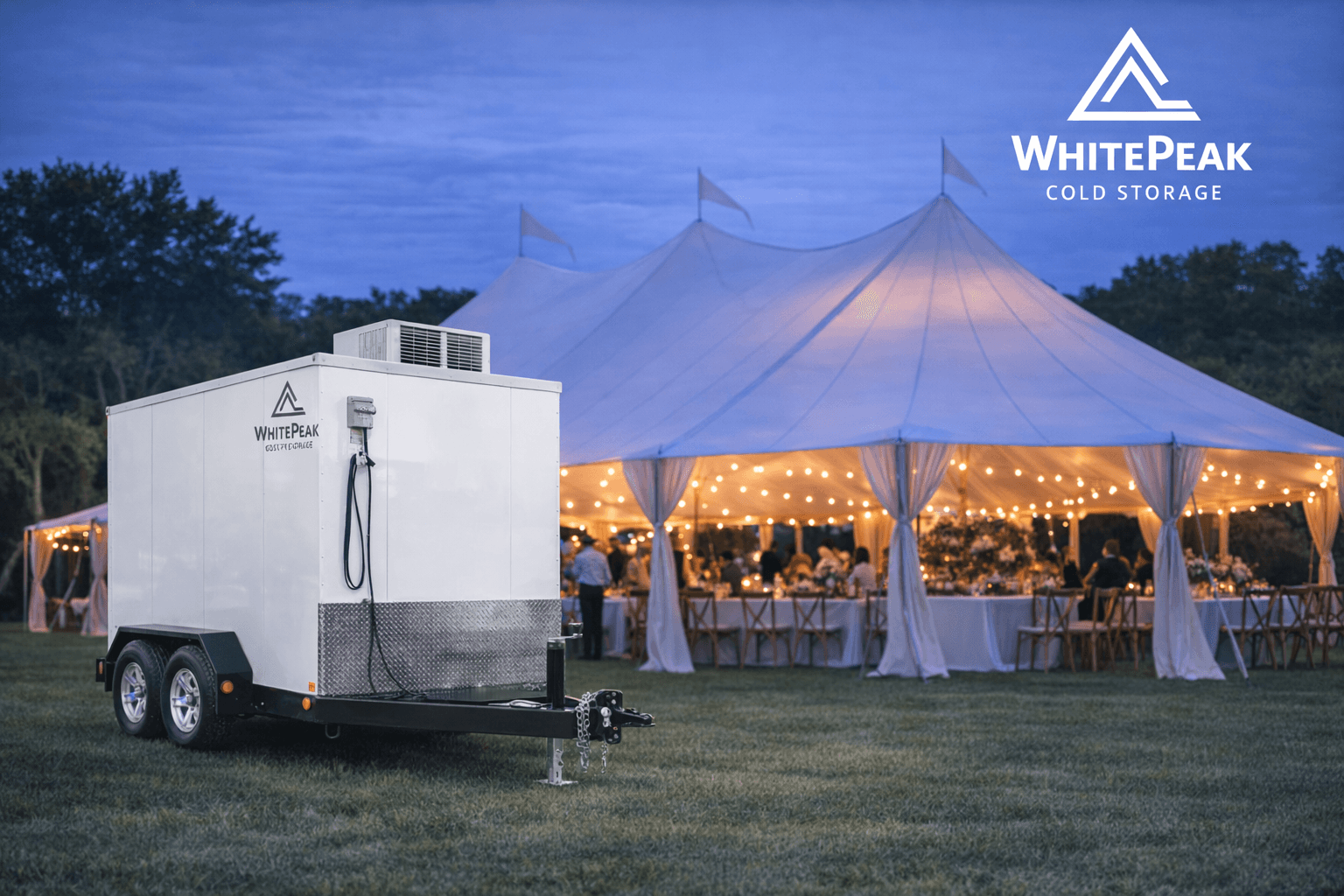 WhitePeak mobile cold storage trailer parked beside a large, illuminated event tent at dusk.